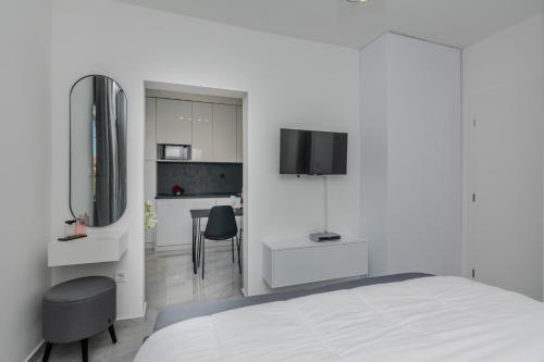 1 dormitorio blanco con 1 cama y cocina en Apartments Anđelka en Bibinje