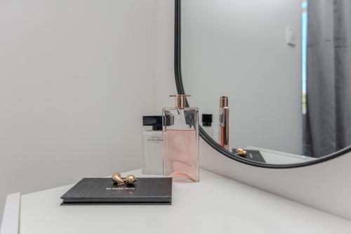 una botella de perfume en un mostrador junto a un espejo en Apartments Anđelka en Bibinje