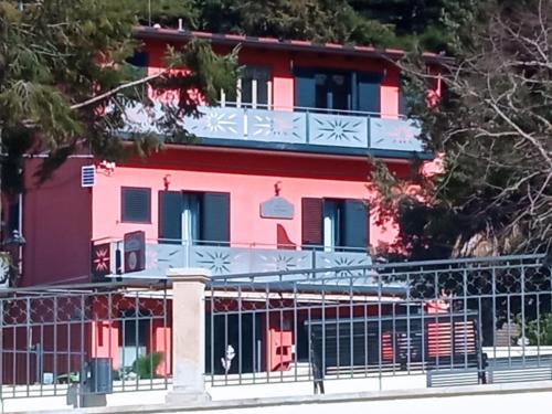 a pink house with a fence in front of it at Eraldo Bed and breakfast in Cesarò