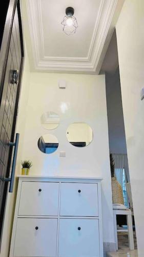 een wit dressoir in een kamer met een plafond bij F3 Chic et Cosy très accessible in Dakar
