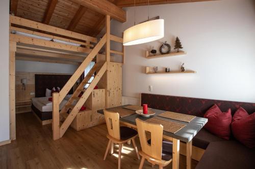 a living room with a table and a loft bed at Piburg Studios in Oetz
