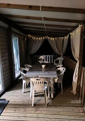 une terrasse en bois avec une table et des chaises en bois dans l'établissement Mobil-home, à Canet