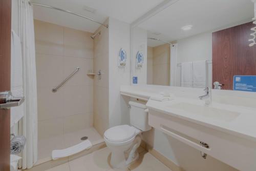 La salle de bains est pourvue de toilettes, d'un lavabo et d'une douche. dans l'établissement City Express by Marriott Minatitlán, à Minatitlán