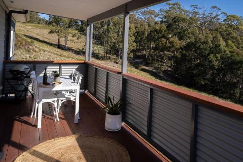 a balcony with a table and two chairs on it at Kalang BnB St Helens in St Helens