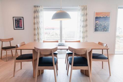 een eetkamer met een houten tafel en stoelen bij 3 BR Villa for 7 guests in Tórshavn in Tórshavn