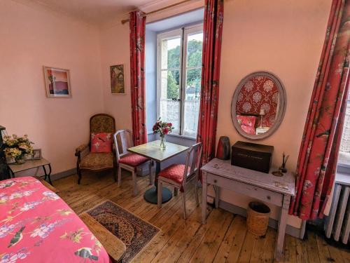 una camera da letto con tavolo, finestra, tavolo e sedie di Chailland Home with a view a Chailland