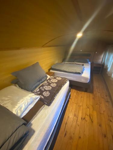 two beds in a room with a wooden floor at Refugio en Malalcahuello in Malalcahuello