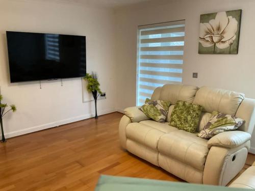 sala de estar con sofá y TV de pantalla plana en Exclusive 3 Bed Home-5 mins from Lakeside Shopping Mall en West Thurrock