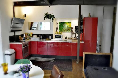 Il comprend une cuisine équipée de placards rouges et d'un réfrigérateur rouge. dans l'établissement Nice - Stylish apartment downtown, à Nice