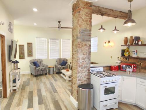 Una cocina con electrodomésticos blancos y una columna de ladrillo. en Orange Delite, en Indianápolis