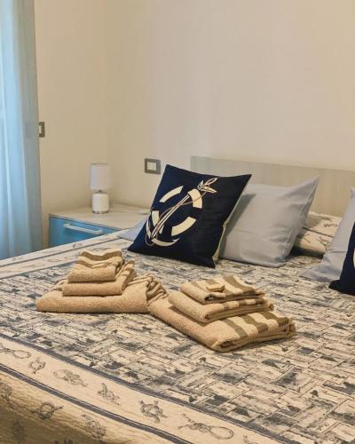 a group of towels sitting on top of a bed at Holiday Rooms La Campagnetta in Alassio