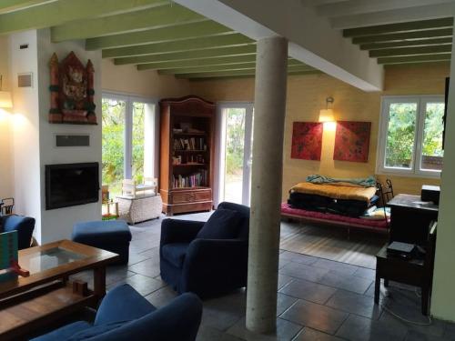 un salon avec un canapé et un lit dans l'établissement La Villa Varanguaise 3 étoiles Lacanau, à Lacanau