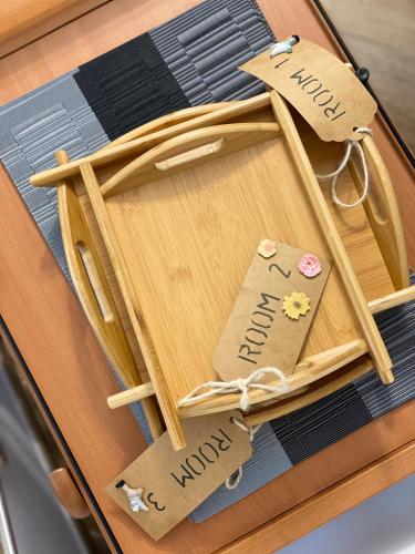 a wooden tray with two tags on a table at Holiday Rooms La Campagnetta in Alassio