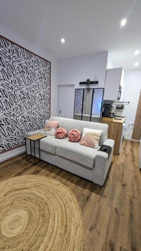 un salon avec un canapé et un tapis dans l'établissement Le Charme Rosé, à Villejuif