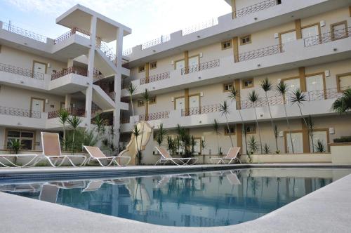 un hôtel avec une piscine en face d'un bâtiment dans l'établissement Hotel Mediterraneo, à Ciudad Madero