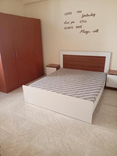 1 dormitorio con 1 cama con escritura en la pared en agriturismo Kreshta, en Lezhë