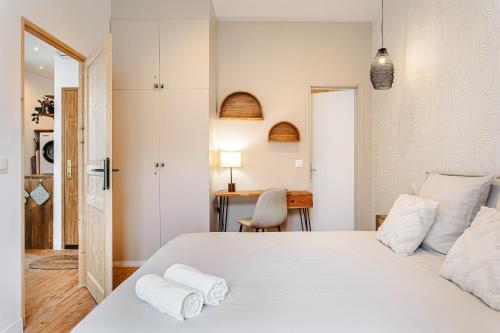 a bedroom with a large white bed and a desk at Cosy appart proche du marché in La Rochelle