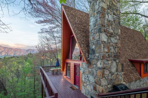 a house with a stone chimney and a deck at Gatlinburg Cabin With Breathtaking Views, Hot Tub, Sauna, 10 min to downtown and National Park in Gatlinburg