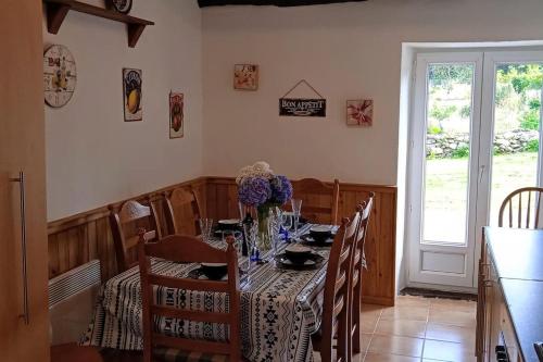 une salle à manger avec une table et des chaises et une fenêtre dans l'établissement Tranquillity Cottage, à Mégrit