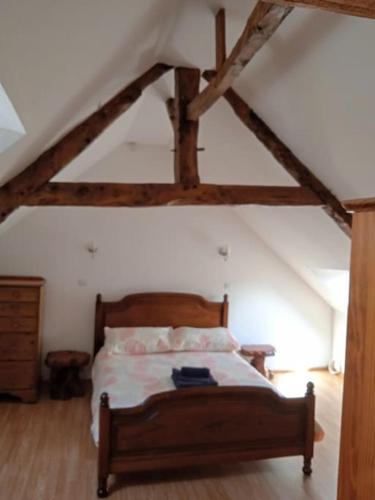 - une chambre mansardée avec un lit en bois dans l'établissement Tranquillity Cottage, à Mégrit