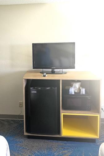 a flat screen tv sitting on top of a entertainment center at Days Inn by Wyndham North Sioux City in North Sioux City