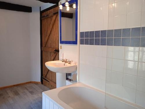 une salle de bain avec un lavabo et une baignoire dans l'établissement Tranquillity Cottage, à Mégrit