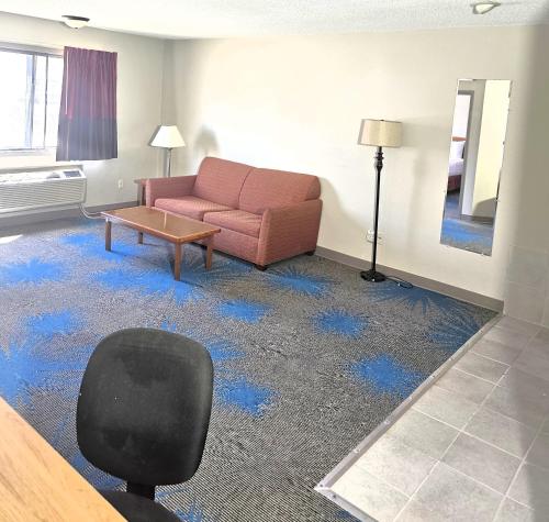 a living room with a couch and blue carpet at Days Inn by Wyndham North Sioux City in North Sioux City