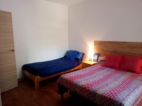 a bedroom with two beds and a lamp on a table at Cortijo Rural Al-Andalus con Piscina in Órgiva