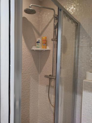 une douche avec une porte vitrée avec un cœur sur le mur dans l'établissement Chez nous et Chez vous STUDIO, à Paris