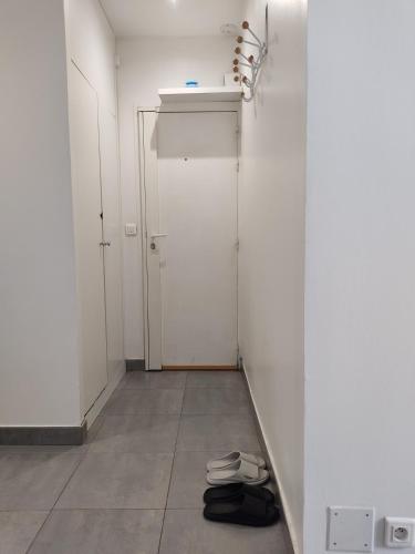 Cette chambre dispose de murs blancs, d'une porte et de carrelage. dans l'établissement Chez nous et Chez vous STUDIO, à Paris