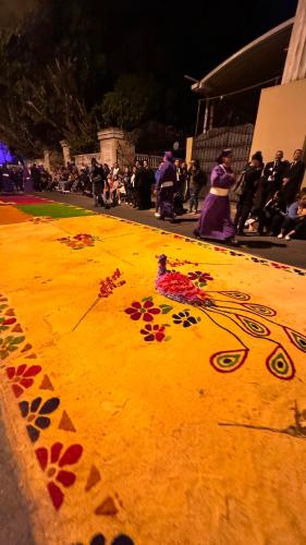 a group of people standing around a painting of flowers at CASA DE LAS FLORES in Guatemala