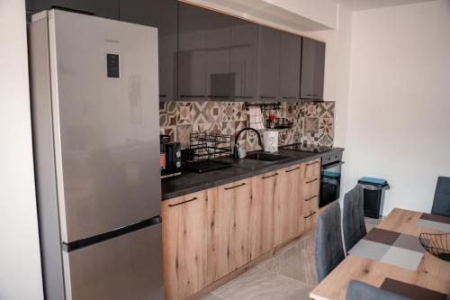 cocina con armarios de madera y nevera blanca en Darki Apartments 4 - Very Central 100 Square Meters,Two Bedrooms,Free Parking en Ohrid