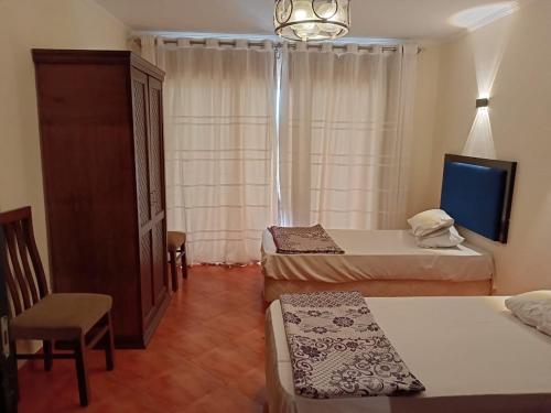 a hotel room with two beds and a tv at Porto marina in El Alamein