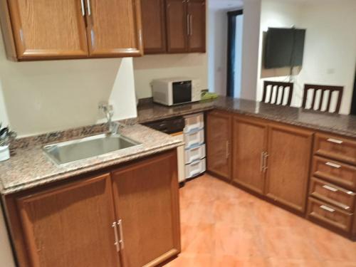 a kitchen with wooden cabinets and a sink and a microwave at Porto marina in El Alamein