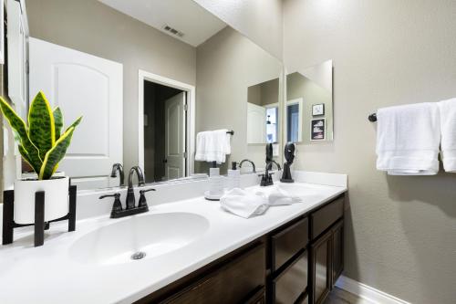 een badkamer met een wastafel en een grote spiegel bij Millay’s Home Vacation in Indio