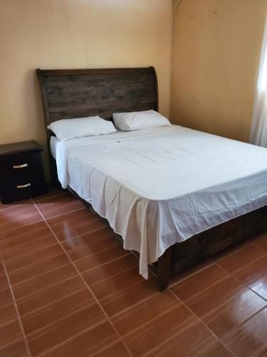 a bedroom with a large bed with white sheets at Lind's comfort place in Roseau