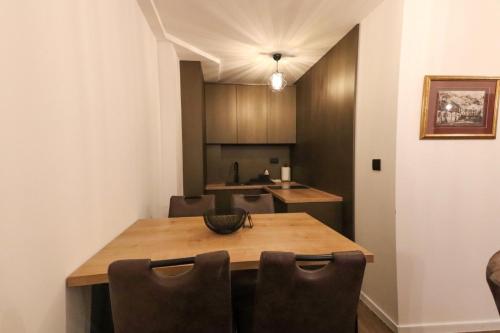 a dining room with a wooden table and chairs at Apartmani Fantasia Cetinje in Cetinje