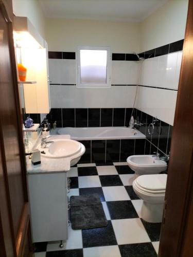 a bathroom with a black and white checkered floor at CASA Bela Vista in Machico