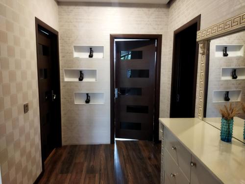 uma casa de banho com um toucador, um espelho e uma porta em Tatil evi em Sheki