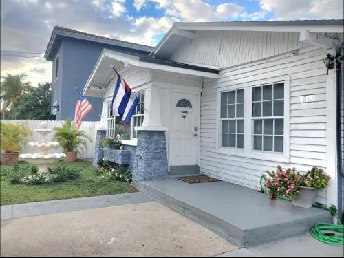 a white house with two american flags on it at B4 Best Value on Private Bedroom with Private Bathroom in Little Havana, Miami in Miami