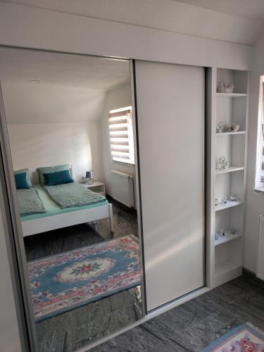 eine Spiegelung eines Schlafzimmers mit einem Bett und einem Bettsofa in der Unterkunft Apartment Sofia in Bihać