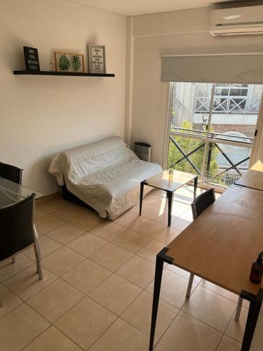 um quarto com uma cama, uma mesa e uma janela em Departamento Ciudad Jardín em Billinghurst