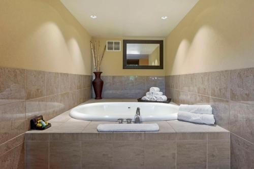 Best Western Plus Coeur d'Alene Inn في كور دالان: حمام مع حوض استحمام مع حوض