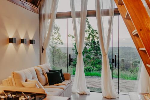 a living room with a couch and a large window at Cabana Jurupará in Piedade
