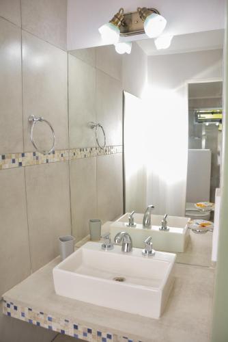 a bathroom with a white sink and a mirror at POSADA ROSSINA Habitaciones con baño privado y ambientes compartidos in San Rafael
