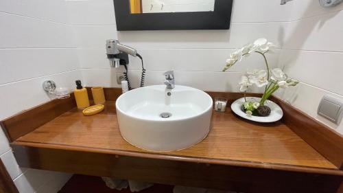 - un lavabo blanc sur un comptoir en bois dans la salle de bains dans l'établissement VILLA TAAROA LEGENDS, à Haapiti