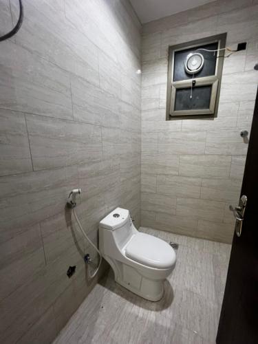 uma casa de banho com um WC branco e uma janela em شقة بدخول ذاتي غرفتين نوم وصالة em Al-Kharj