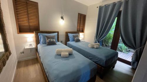 duas camas com ursinhos de peluche num quarto em VILLA TAAROA LEGENDS em Haapiti