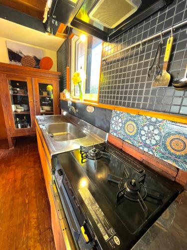 a kitchen with a stove top and a sink at SHIZENTOYA Privete cottage for nature experience LakeView! in Lake Toya