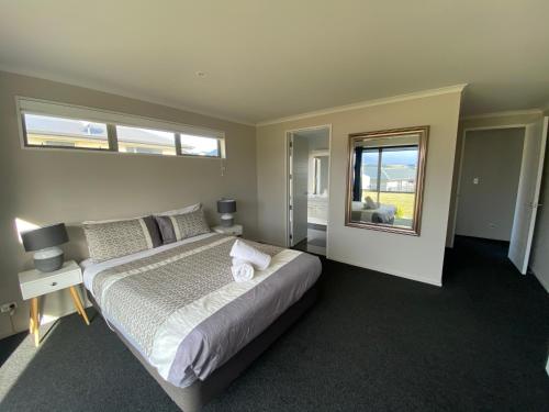 a bedroom with a large bed and a window at Southholm in Lake Tekapo
